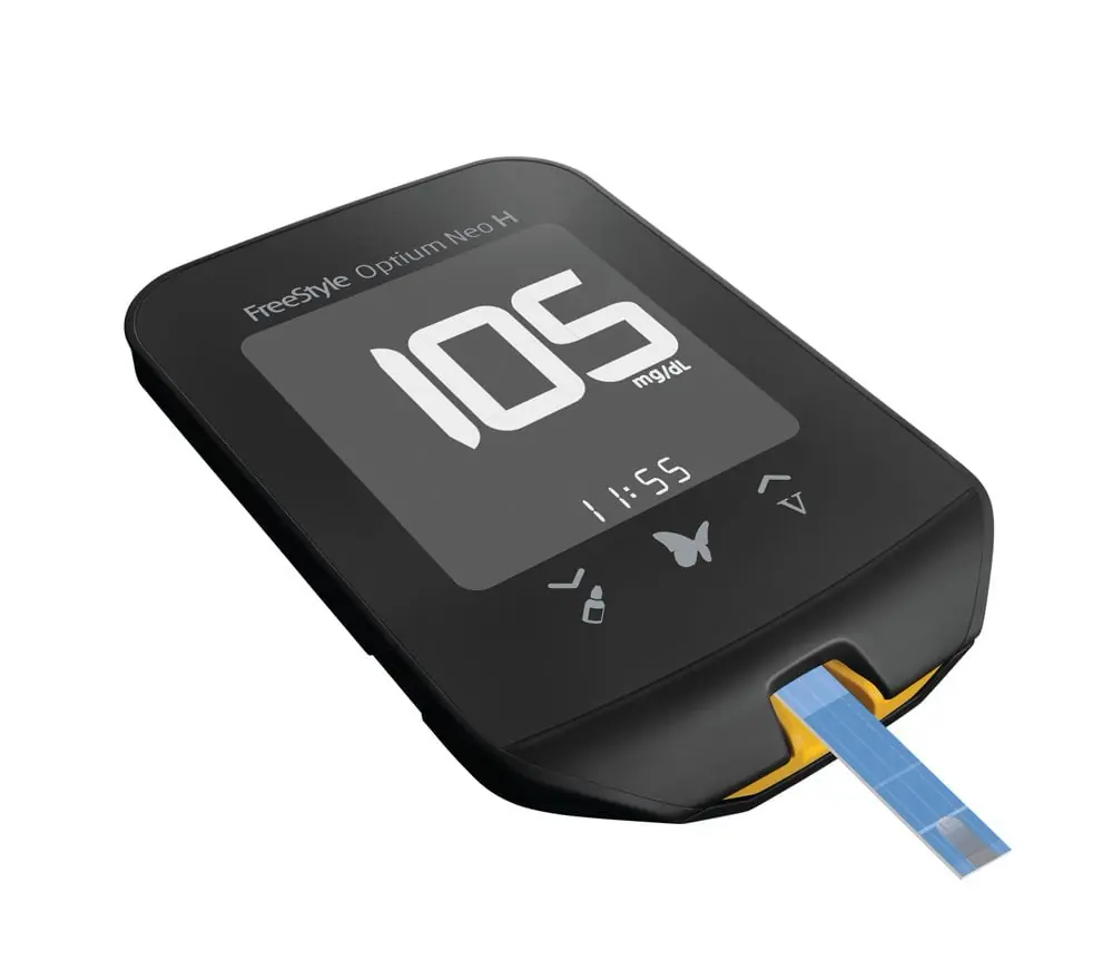 Aparelho FreeStyle Optium Neo H com visor digital exibindo resultado em mg/dL e tira de teste inserida.