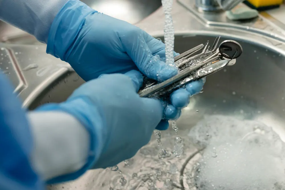 Limpeza de instrumentos com detergente enzimático em pia hospitalar com uso de luvas
